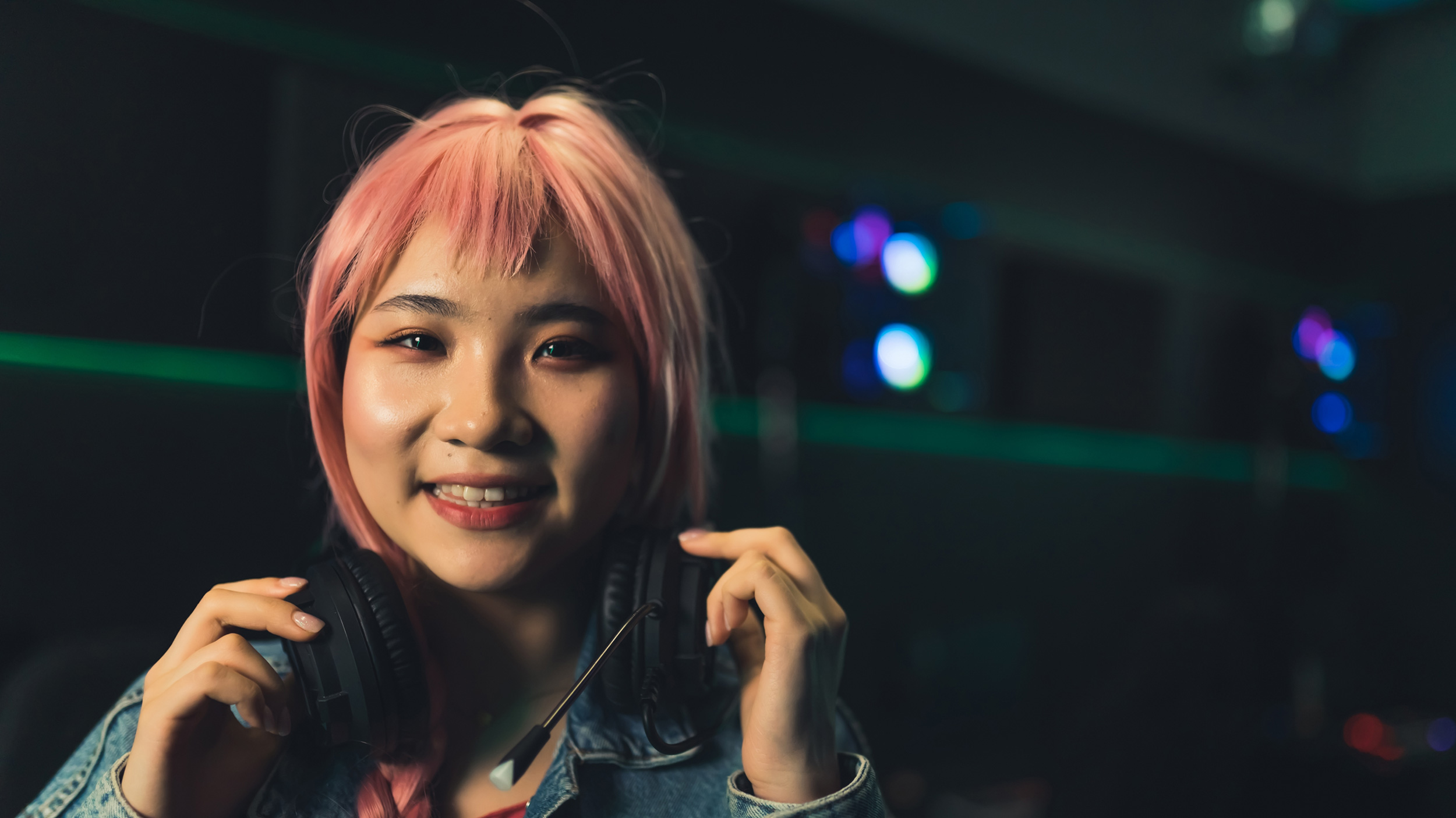 A girl smiling, holding headphones.