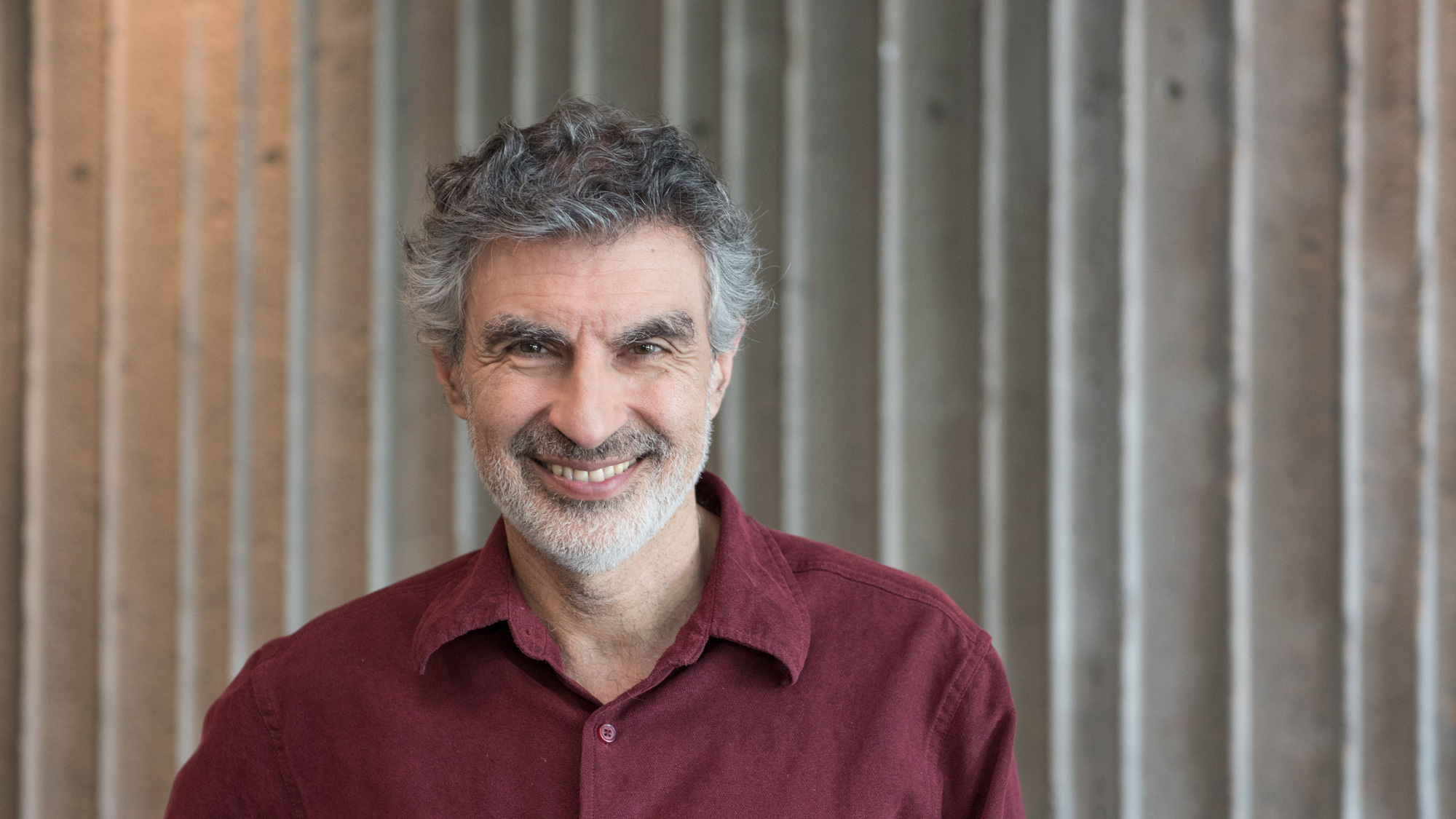 Headshot Photo of Yoshua Bengio in a red shirt.