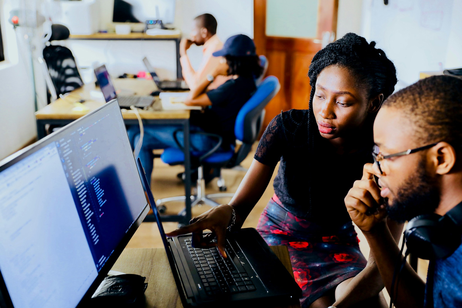 A mentor teaching a student at a laptop